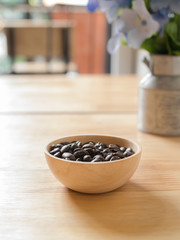 Roasted coffee beans in wooden bowl