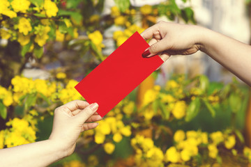 Hand give money in red envelopes - ang pow or red packet to some