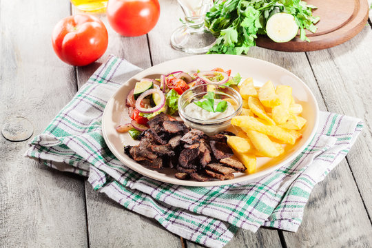 Grilled meat with French fries and fresh vegetables
