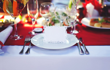 Beautiful decorated place at the table with the guest card on ho