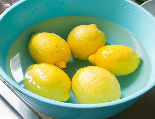 Fresh lemon in a blue bowl with water