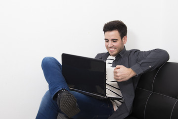 male young in the sofa's House with the computer laptop