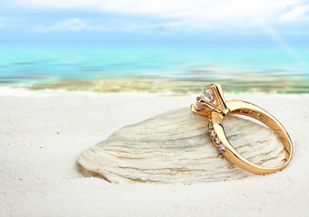 Jewellry ring with big diamond on sand beach with copy space, so