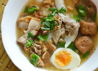 Chinese rice flour paste with pork and entrails topping creamy egg yolk in soup