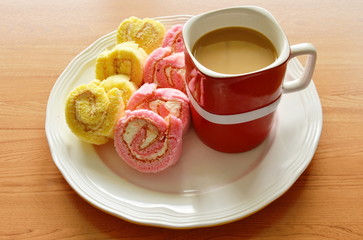 mini strawberry and vanilla jam roll fit for one piece with coffee red cup on plate