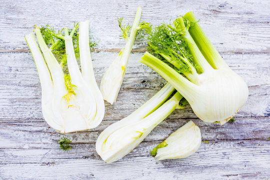 Fresh and raw fennel bulbs on wooden background.
