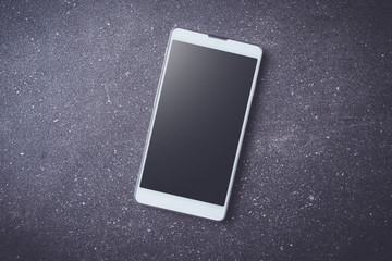 White smart phone on dark stone table