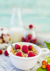 Muesli and yogurt with fresh raspberry fruit on wooden background. 