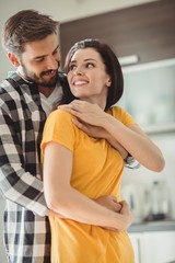 Fototapeta premium Portrait of happy couple embracing in kitchen 