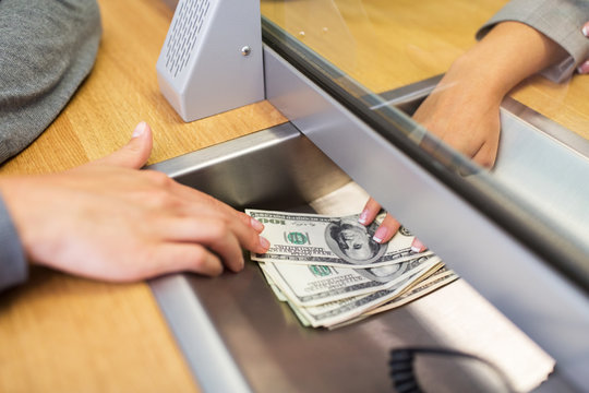 clerk giving cash money to customer at bank office