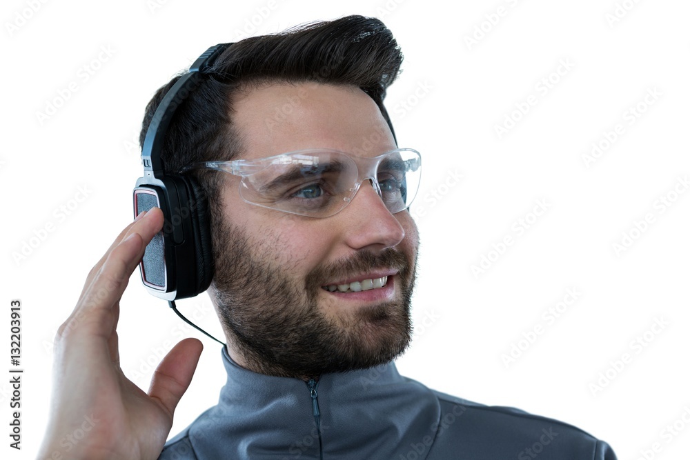 Wall mural Man in protective glasses listening to headphones