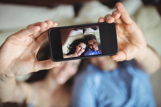 Romantic couple relaxing on bed and taking a selfie
