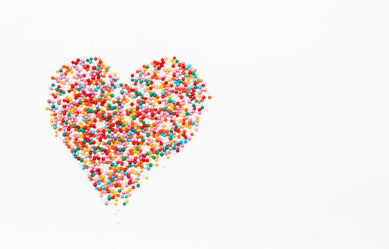 sprinkles in heart shape on white background. Festive background for Valentine's day, birthday, holiday, party