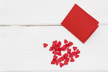 red card and a few little hearts around. romantic love background for Valentine's day, birthday, holiday, party