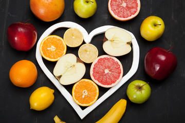 Fruits and heart on black background