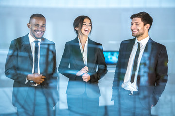 The three business people stand over the window