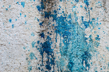 Old white concrete wall with blue dye stains
