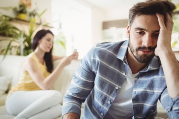 Upset couple ignoring each other on sofa