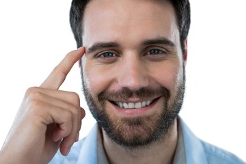 Smiling man with finger pointing to head