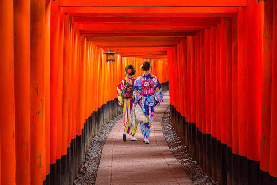 Fototapeta Women in traditional japanese kimonos walking at Fushimi Inari Shrine in Kyoto, Japan
