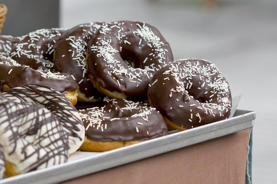 Big chocolate donuts on a tray.