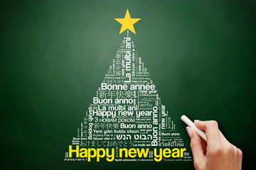 Happy New Year in different languages, celebration word cloud greeting card in the shape of a christmas tree on blackboard