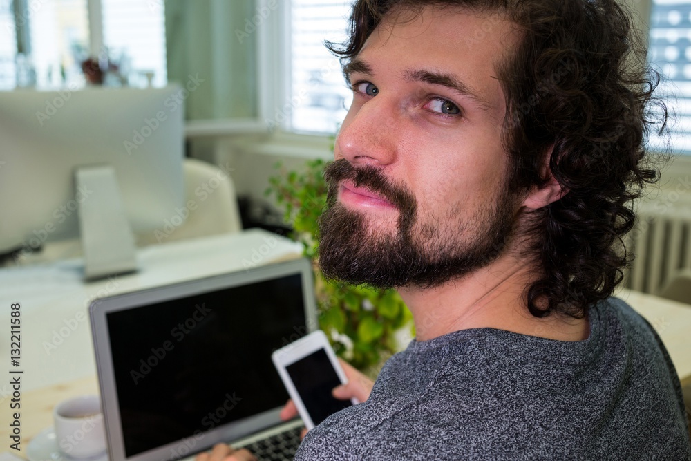 Aufkleber graphic designer using mobile phone at his desk