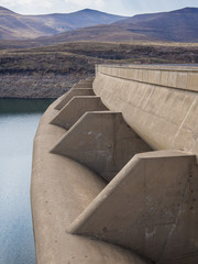 Concrete dam wall and overflow of impressive Katse Dam hydroelectric power plant in Lesotho, Africa