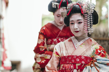  Maiko geishas walking on a street of Gion - 132211940