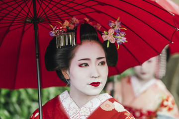  Maiko geishas walking on a street of Gion