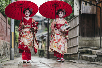 Maiko geishas walking on a street of Gion