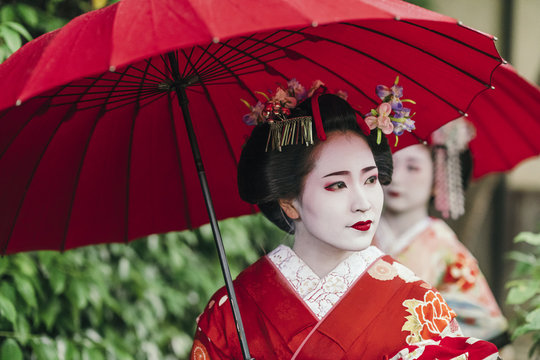  Maiko geishas walking on a street of Gion