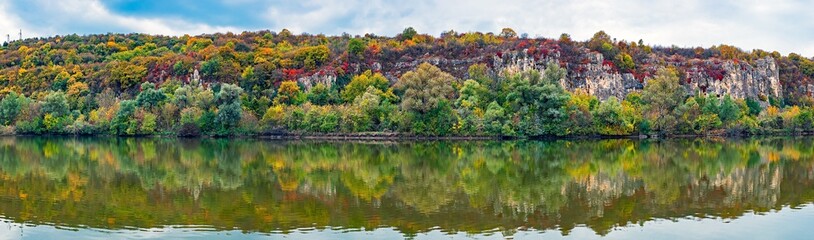 Rocks covered in greenery in fall colors reflected on the river. Rusenski Lom Natural Park, Ruse district, Bulgaria, 6frame