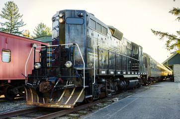 Fototapeta premium Train with Black Locomotive in Station at Sunset