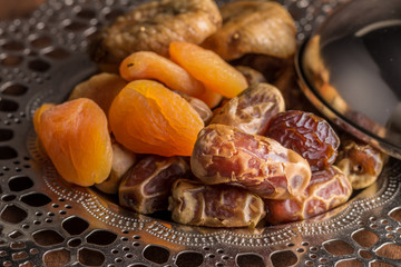 Closeup pf Plate of dates and dried fruits with cover