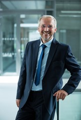 Smiling businessman standing in office lobby