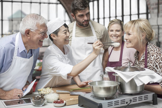 Group of people taking cooking course