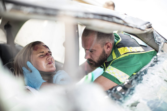 Paramedic helping car crash victim after accident