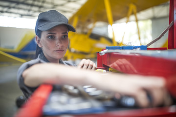 Mechanic in hangar repairing light aircraft