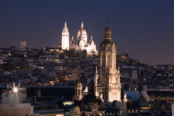 Fototapeta na wymiar Aerial view of Sacre-Coeur Basilica or Basilica of the Sacred Heart of Jesus at the butte Montmartre and Saint Trinity church at night, Paris, France