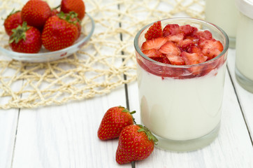 Strawberry yogurt on the white wooden background. Healthy diet