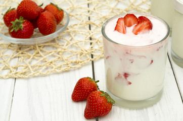 Strawberry yogurt on the white wooden background. Healthy diet