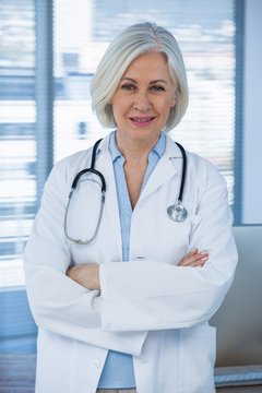 Portrait of a smiling female doctor standing with arms crossed