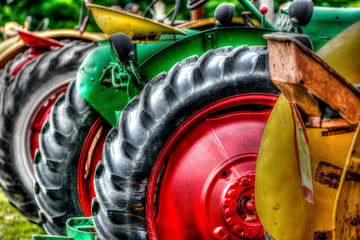 Close up photograph of a row of old tractors at a rural farm auction