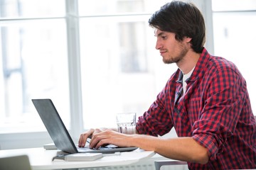 Fototapeta premium Graphic designer using laptop at his desk