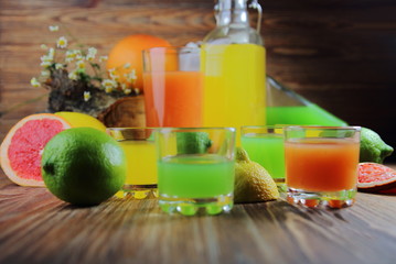 цитрусовые соки в рюмках с лимоном,лаймом и грейпфрутом