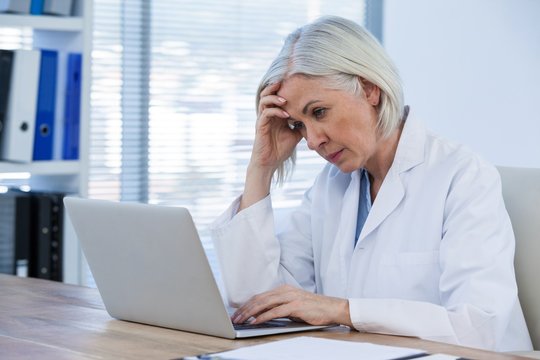 Tense Female Doctor Working On Her Laptop