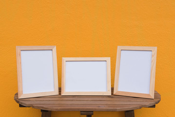 three photo Frame on a wooden on Yellow background .