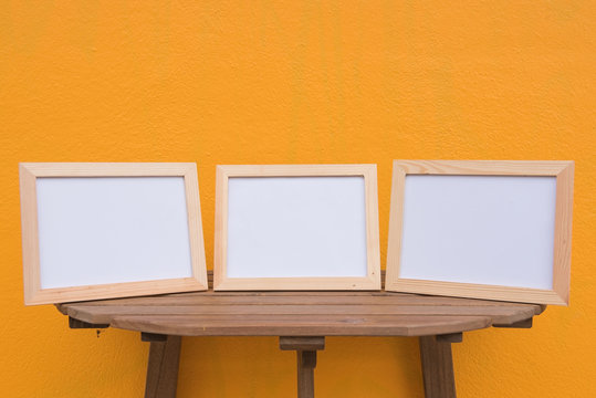 three photo Frame on a wooden on Yellow background .