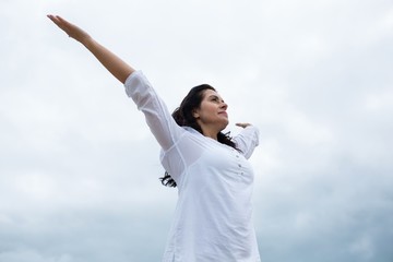 Happy woman standing with arms outstretched